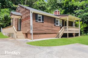 Marietta house for rent - a small brown house with a porch and a driveway