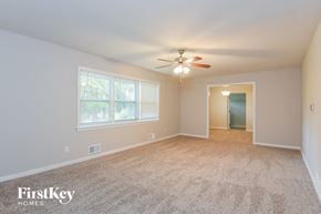 Marietta house for rent - a empty living room with a ceiling fan and a window