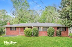 Marietta house for rent - a brick house with a lawn and some bushes