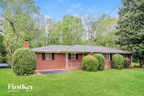 Marietta house for rent - a small brick house with a yard and some bushes