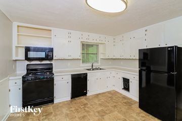 Marietta house for rent - a kitchen with black appliances and white cabinets
