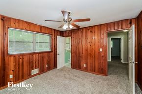 Marietta house for rent - a bedroom with wood paneled walls and a ceiling fan