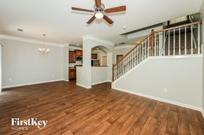 Lawrenceville house for rent - A spacious living room with wood flooring and a ceiling fan.