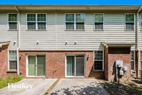 Lawrenceville house for rent - A brick building with a grey siding and a sign that says "FirstKey Homes".