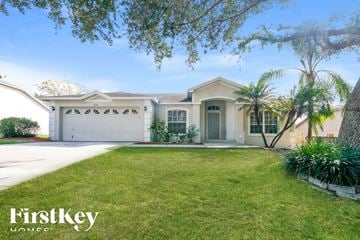 Lakeland house for rent - a house with a lawn and palm trees