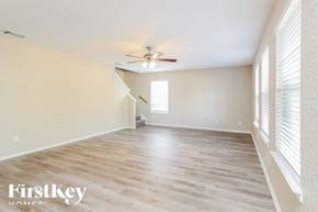 New Braunfels house for rent - A spacious room with a ceiling fan and wooden flooring.