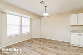 New Braunfels house for rent - A room with wooden flooring and a hanging light fixture.