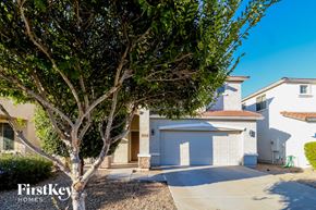 Surprise house for rent - a street view of a house with a driveway and a tree