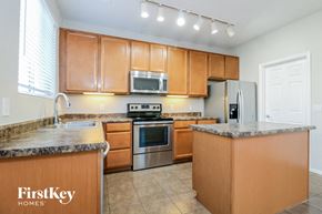 Surprise house for rent - a kitchen with wooden cabinets and stainless steel appliances