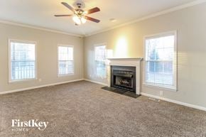 High Point house for rent - an empty living room with a fireplace and a ceiling fan