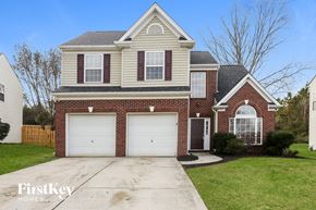 Charlotte house for rent - a brick house with two garage doors and a lawn