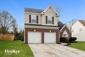 Charlotte house for rent - a brick house with two garage doors and a lawn