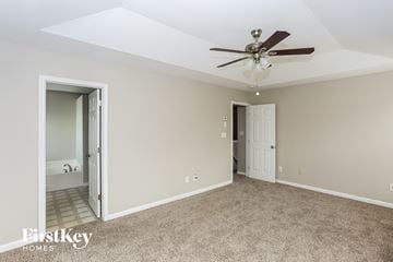 Charlotte house for rent - a living room with carpet and a ceiling fan