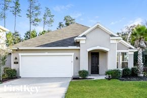 Jacksonville house for rent - a white house with a garage and a lawn