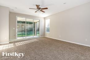 Jacksonville house for rent - an empty living room with a ceiling fan and a window