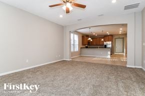 Jacksonville house for rent - an empty living room and kitchen with a ceiling fan