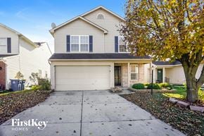 Indianapolis house for rent - a white house with a white garage door and a tree