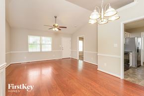 High Point house for rent - A spacious room with wooden floors and a ceiling fan.