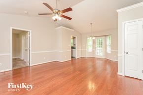 High Point house for rent - A spacious room with a ceiling fan and wooden flooring.