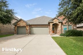 Burleson house for rent - A brick house with a garage door and a driveway.