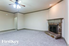 Burleson house for rent - A room with a fireplace and a ceiling fan.