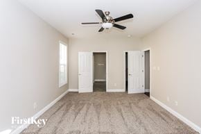 Charlotte house for rent - A spacious room with a ceiling fan and carpeted floor.