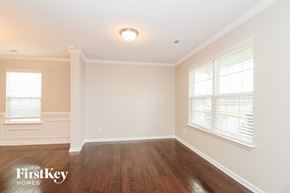 Whitsett house for rent - A room with wooden floors and white walls, with a window on the left side.
