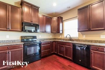 Morrow house for rent - A kitchen with brown cabinets and a black dishwasher.