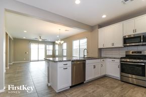 Buckeye house for rent - a large kitchen with white cabinets and stainless steel appliances