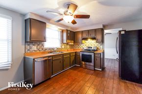 Batavia house for rent - a kitchen with wooden counters and stainless steel appliances and a ceiling fan