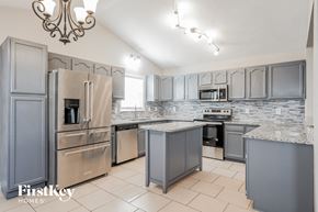 Thomasville house for rent - a kitchen with stainless steel appliances and gray cabinets