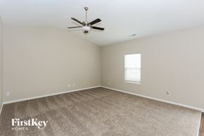 Charlotte house for rent - A spacious room with a ceiling fan and a window with blinds.