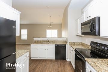 Charlotte house for rent - A kitchen with granite countertops and white cabinets.