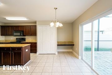 Riverview house for rent - A kitchen with brown cabinets and a black microwave.