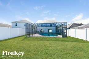 Riverview house for rent - A backyard with a pool and a white fence.
