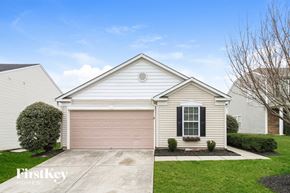 Winston Salem house for rent - A house with a garage door and a window with black shutters.
