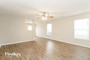 Winston Salem house for rent - A spacious room with wooden flooring and a ceiling fan.