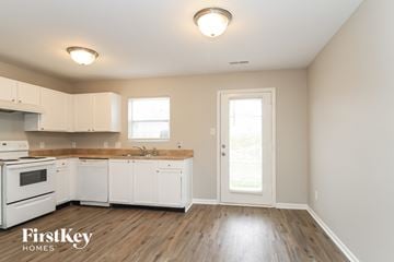 Winston Salem house for rent - A kitchen with white cabinets and a wooden countertop.