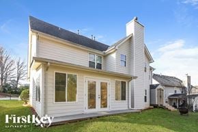 Dacula house for rent - A two-story house with a white exterior and a black roof is for sale.
