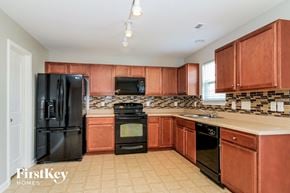 Winston Salem house for rent - a kitchen with black appliances and wooden cabinets