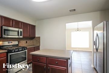Baytown house for rent - a kitchen with wooden cabinets and stainless steel appliances