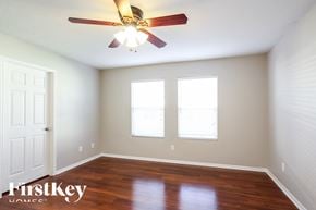 Baytown house for rent - a bedroom with a ceiling fan and two windows