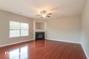 Lexington house for rent - A living room with a fireplace and a ceiling fan.