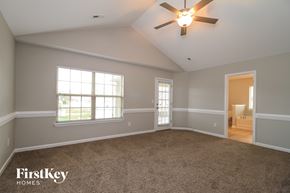 Lexington house for rent - A spacious room with a ceiling fan and two windows.