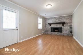 Lawrenceville house for rent - A room with a fireplace and wooden floors.