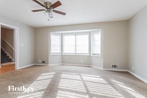 Lawrenceville house for rent - A spacious room with a carpeted floor and a ceiling fan.