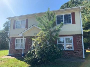 Raleigh apartment for rent - A house with a red brick exterior and a yellow roof with a tree in front.
