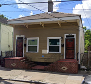 New Orleans apartment for rent - A yellow house with a red door and a window.