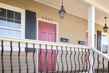 New Orleans apartment for rent - a porch with red chairs and a pink door
