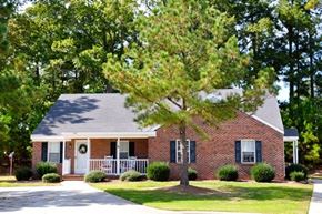 Clayton apartment for rent - A brick house with a white door and a tree in front.